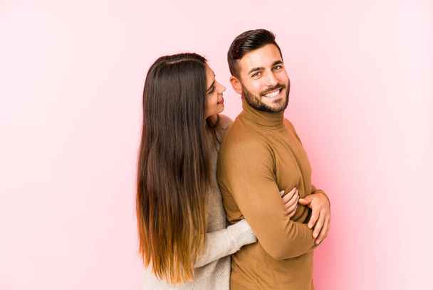Young caucasian couple isolated looks aside smiling, cheerful and pleasant. - Photo, Image