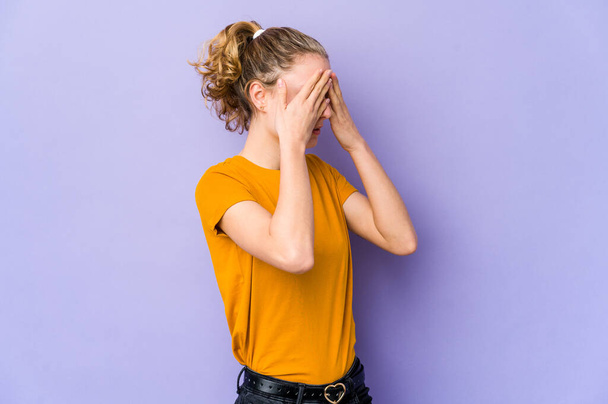 Young caucasian woman on purple background afraid covering eyes with hands. - Foto, afbeelding