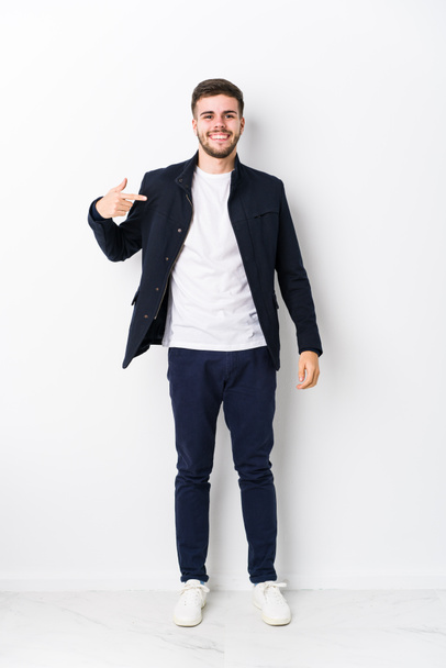 Full body young caucasian man isolated person pointing by hand to a shirt copy space, proud and confident - Photo, image