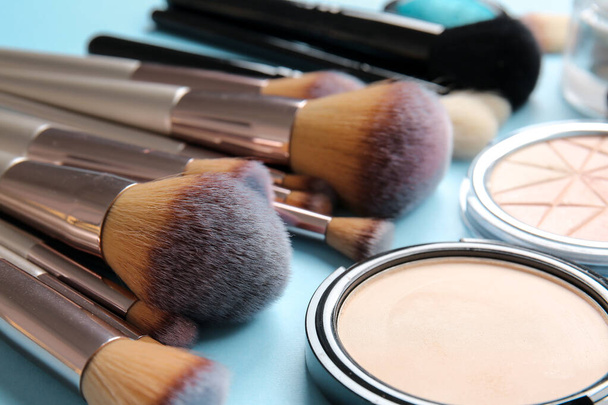 Conjunto de pincéis de maquiagem e cosméticos no fundo de cor, close-up - Foto, Imagem