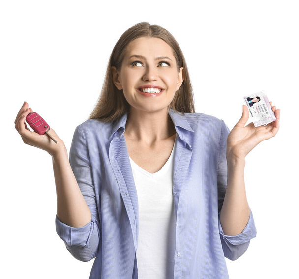 Happy young woman with driving license and car key on white background - Photo, Image