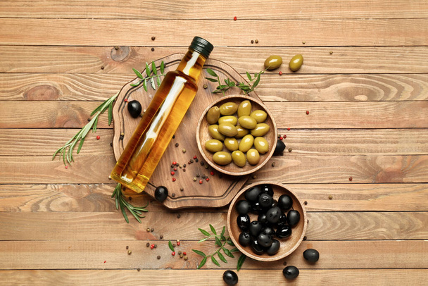 Composition with canned olives and oil on wooden background - 写真・画像