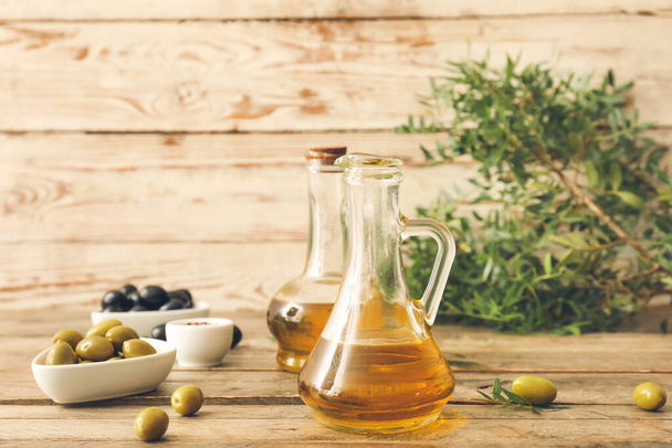 Jugs of olive oil on wooden table - Photo, Image