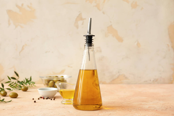 Пляшка оливкової олії на столі
 - Фото, зображення