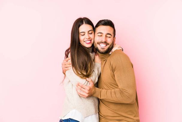 Mladý kavkazský pár izolované objetí, usmívající se bezstarostně a šťastný. - Fotografie, Obrázek