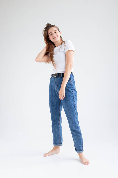 young caucasian woman in t-shirt and blue jeans isolated on white background - Photo, Image