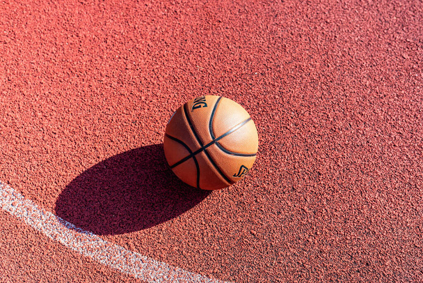 Telsiai, Litva 08 12 2020 oranžový míč pro basketbal na gumovém hřišti. - Fotografie, Obrázek