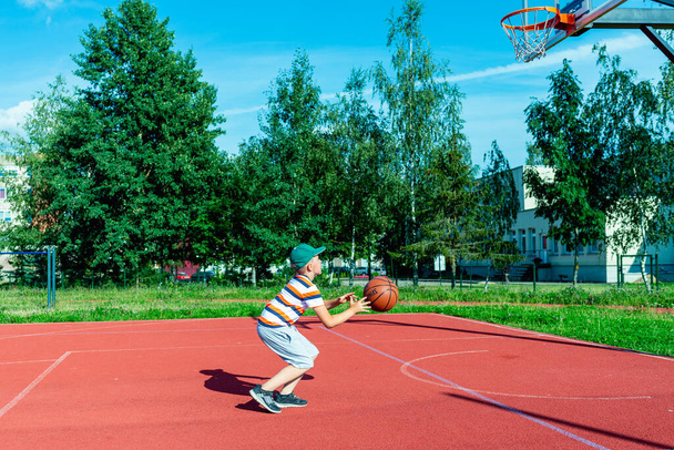 Telsiai, Lituanie 08 12 2020 Petit joueur de basket-ball caucasien attrayant s'entraînant sur un terrain rouge extérieur - Photo, image