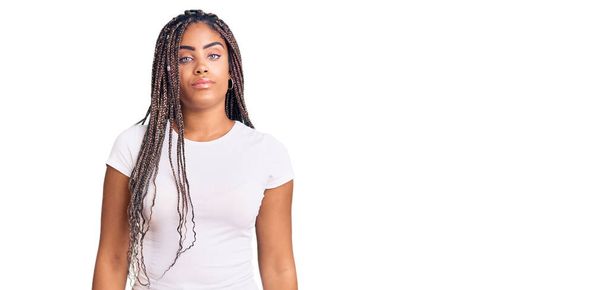 Young african american woman with braids wearing casual clothes relaxed with serious expression on face. simple and natural looking at the camera.  - Foto, Bild