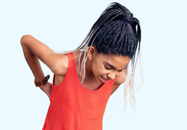 Sevimli Afro-Amerikalı kız gündelik kıyafetler giyiyor sırt ağrısı çekiyor, elleriyle dokunuyor, kas ağrısı çekiyor.  - Fotoğraf, Görsel