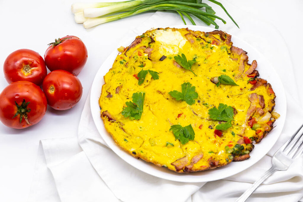finom omlett színes zöldségekkel és reszelt sajttal, paradicsom és friss hagyma félre - Fotó, kép