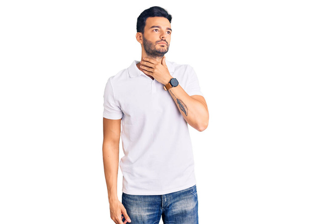 Young handsome hispanic man wearing casual clothes touching painful neck, sore throat for flu, clod and infection  - Foto, afbeelding