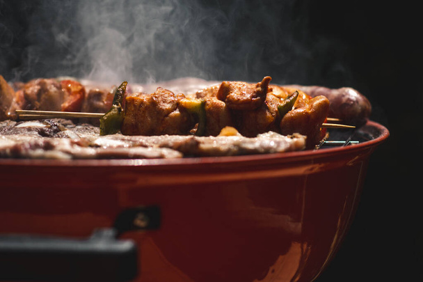 Grilované maso s špejlemi a masem, chutné a lahodné, na grilu s kouřem a plameny doma - Fotografie, Obrázek