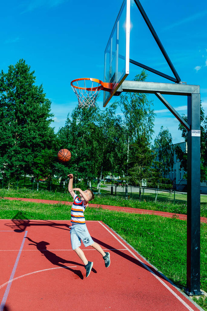 Telsiai, Litvánia 08 12 2020 Vonzó kaukázusi kis kosárlabda játékos tréning a szabadban piros pálya - Fotó, kép