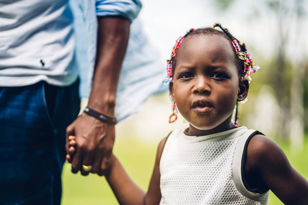 Portrait de jouir heureux amour noir famille afro-américaine père tenant petite fille africaine main dans les moments de bon temps dans le parc d'été à la maison - Photo, image