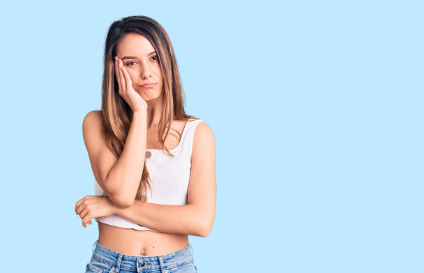 Young beautiful girl wearing casual sleeveless t shirt thinking looking tired and bored with depression problems with crossed arms.  - Photo, Image