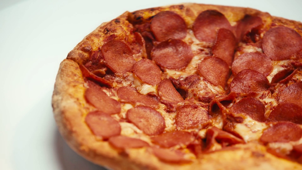 Selectieve focus van heerlijke pizza spinnen op witte achtergrond - Video