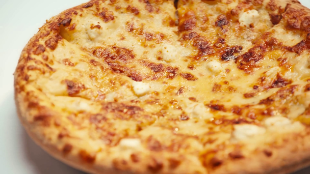 Enfoque selectivo de sabrosa pizza con queso girando sobre fondo blanco - Imágenes, Vídeo