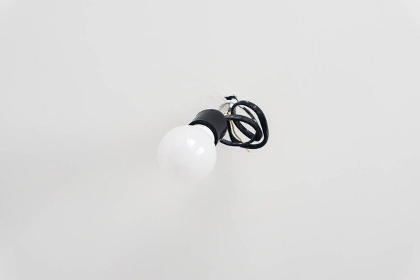 Incandescent lamp in a chuck on the roof, White incandescent lamp without a plafond (chandelier) on a white background - Foto, Imagem