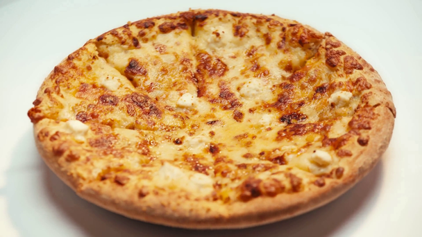 Επιλεκτική εστίαση της πίτσας με τυρί που περιστρέφεται σε λευκό φόντο - Πλάνα, βίντεο
