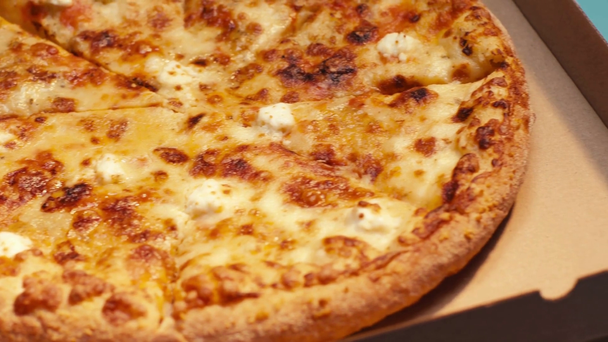 Selective focus of tasty pizza on pizza boxes on blue background - Felvétel, videó