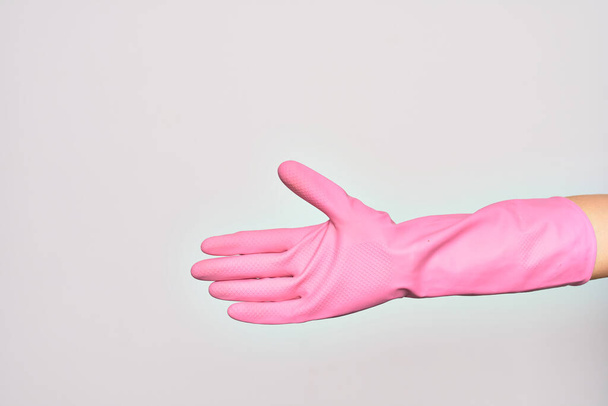 Το χέρι της καυκάσιας νεαρής γυναίκας που φοράει ροζ γάντι καθαρισμού μου δίνει σημάδι. Εμφάνιση ανοιχτής κενής παλάμης πάνω από απομονωμένο λευκό φόντο - Φωτογραφία, εικόνα