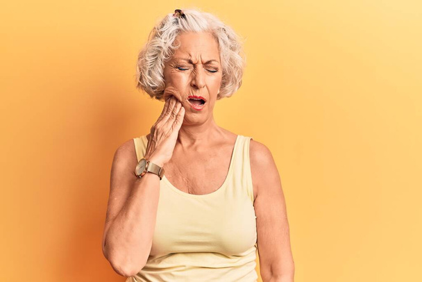 Senior grey-haired woman wearing casual clothes touching mouth with hand with painful expression because of toothache or dental illness on teeth. dentist  - Foto, Bild
