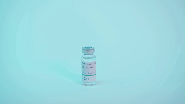 částečný pohled vědce kladení láhve s koronavirem nápisy na modré - Záběry, video