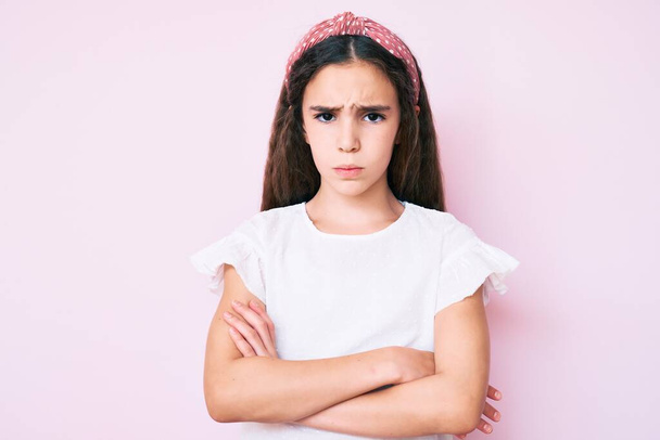 Aranyos spanyol kislány alkalmi ruhát visel és diadém szkeptikus és ideges, rosszalló kifejezés az arcon keresztbe tett karokkal. negatív személy.  - Fotó, kép