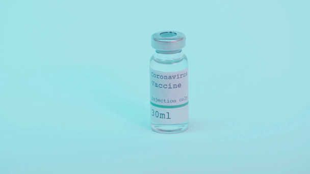 Coronavirus aşısı şişesi, enjeksiyon sadece mavi harfli.  - Video, Çekim