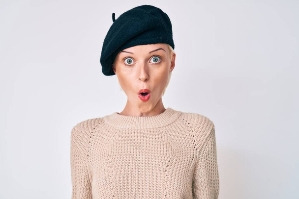 Young blonde woman wearing french look with beret scared and amazed with open mouth for surprise, disbelief face  - Photo, Image