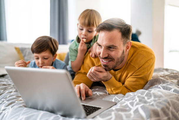 Beautiful happy family with child looking at laptop with cheerful smile at home - Foto, immagini