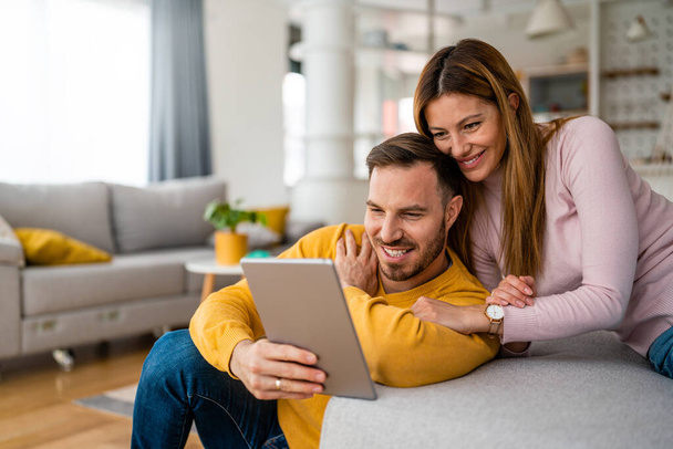 Couple in love using a tablet computer in their living room - Foto, Imagem