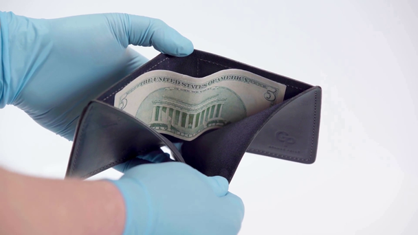 Mann mit Latex-Handschuhen zeigt Dollar im Portemonnaie auf weißem Hintergrund - Filmmaterial, Video