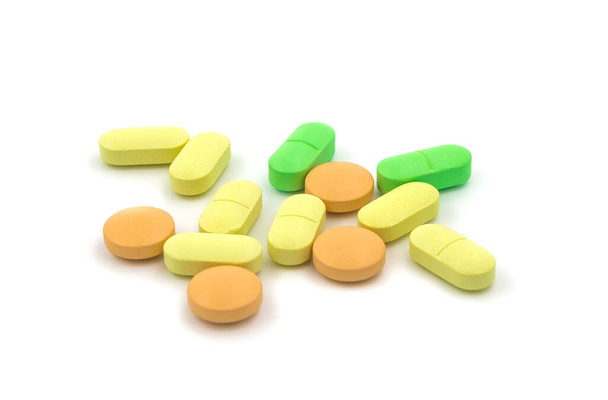 Veelkleurige tabletten en pillen op een witte achtergrond - Foto, afbeelding