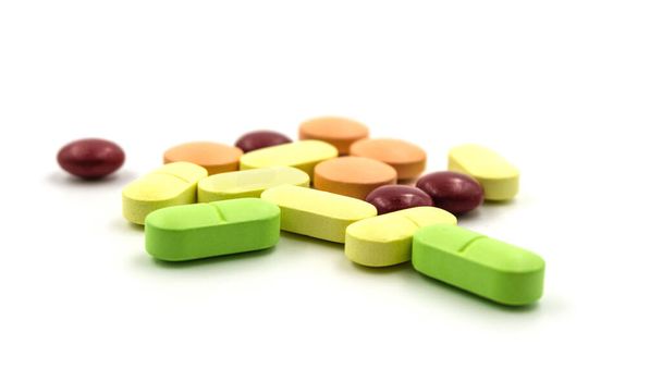 Comprimés et pilules multicolores sur fond blanc - Photo, image