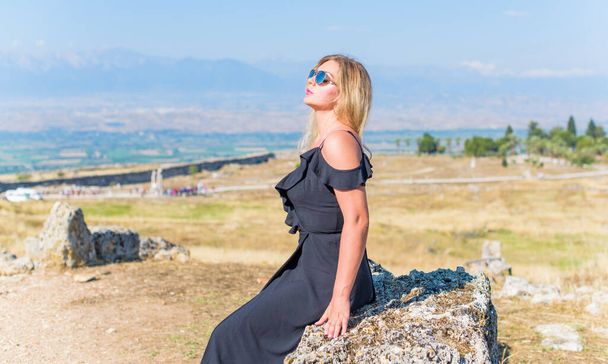 パムッカレに水着で完璧な姿の日光浴を持つ素敵なヨーロッパの女性モデルコットン城人々がトルコで訪問するのが大好きトラバーチンプールやテラス - 写真・画像