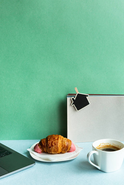 Morning workplace laptop coffee croissant with copy space. Business concept in pastel colors. - Fotó, kép
