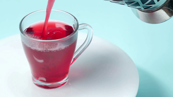Tea öntése teáskannából csészébe a fehér asztalon  - Felvétel, videó