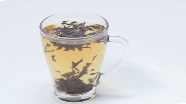 xícara de chá fabricado girando em torno de branco - Filmagem, Vídeo