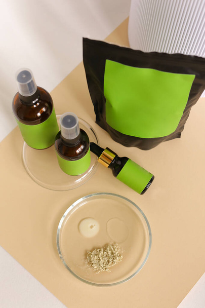 Zbliżenie opakowanie doy i butelki spray z produktem kosmetycznym, zielone miejsce dla marki, glinki w proszku i wody. - Zdjęcie, obraz