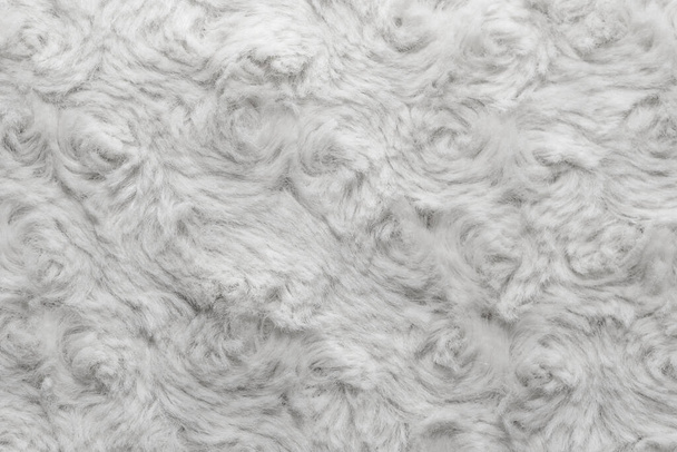 Белая натуральная шерсть с крученым текстурным фоном. Хлопчатобумажная шерсть, ковер из белого шерсти. Меховой ковер с узором - Фото, изображение