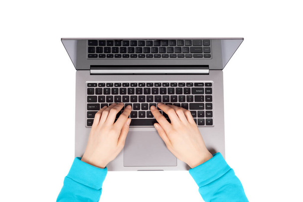 Osoba pracující na notebooku v moderním prostoru. Žena ruce v modré mikině pracuje na novém notebooku izolované na bílém pozadí - Fotografie, Obrázek