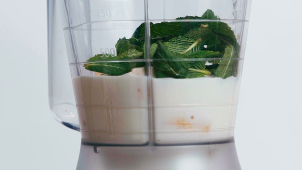 close up of mint falling in blender with milk and banana isolated on white - Footage, Video