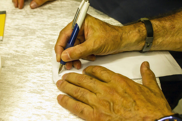 Mano di uomo adulto firma su pape, sopra vista - Foto, immagini