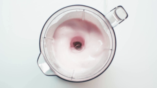 Top view of man touching blender with mixing smoothie on white - Séquence, vidéo