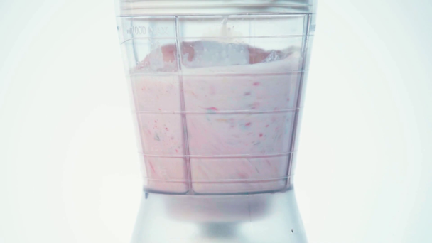 Mezcla lenta de frutas y leche en licuadora aislada en blanco - Imágenes, Vídeo