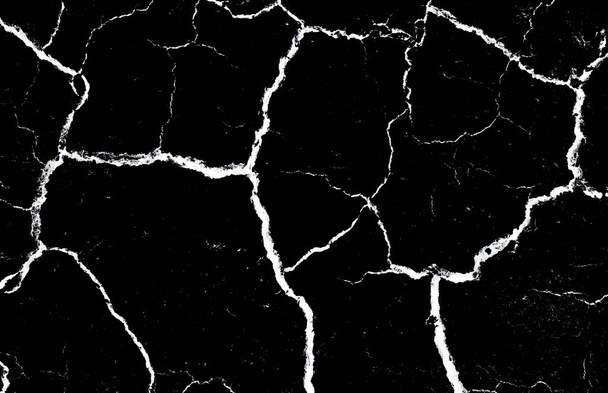 Μαύρο αποξηραμένο και ραγισμένο έδαφος φόντο γης. Κλείσιμο ξηρής σχισμής σε σκοτεινό έδαφος. ρωγμή στην υφή της επιφάνειας. διάβρωση - Φωτογραφία, εικόνα