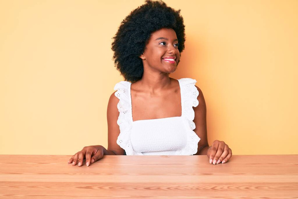 Giovane donna afroamericana che indossa abiti casual guardando da un'altra parte con sorriso sul viso, espressione naturale. ridendo fiducioso.  - Foto, immagini