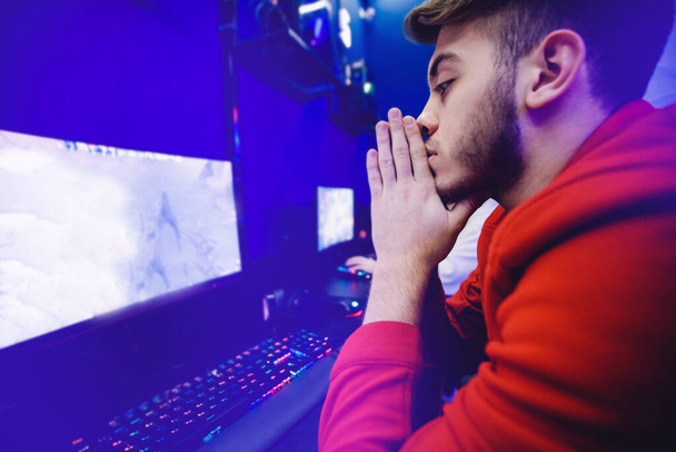 Streamer joven jugador profesional de vídeo lamenta perdedor jugando juegos en línea ordenador, color neón - Foto, imagen